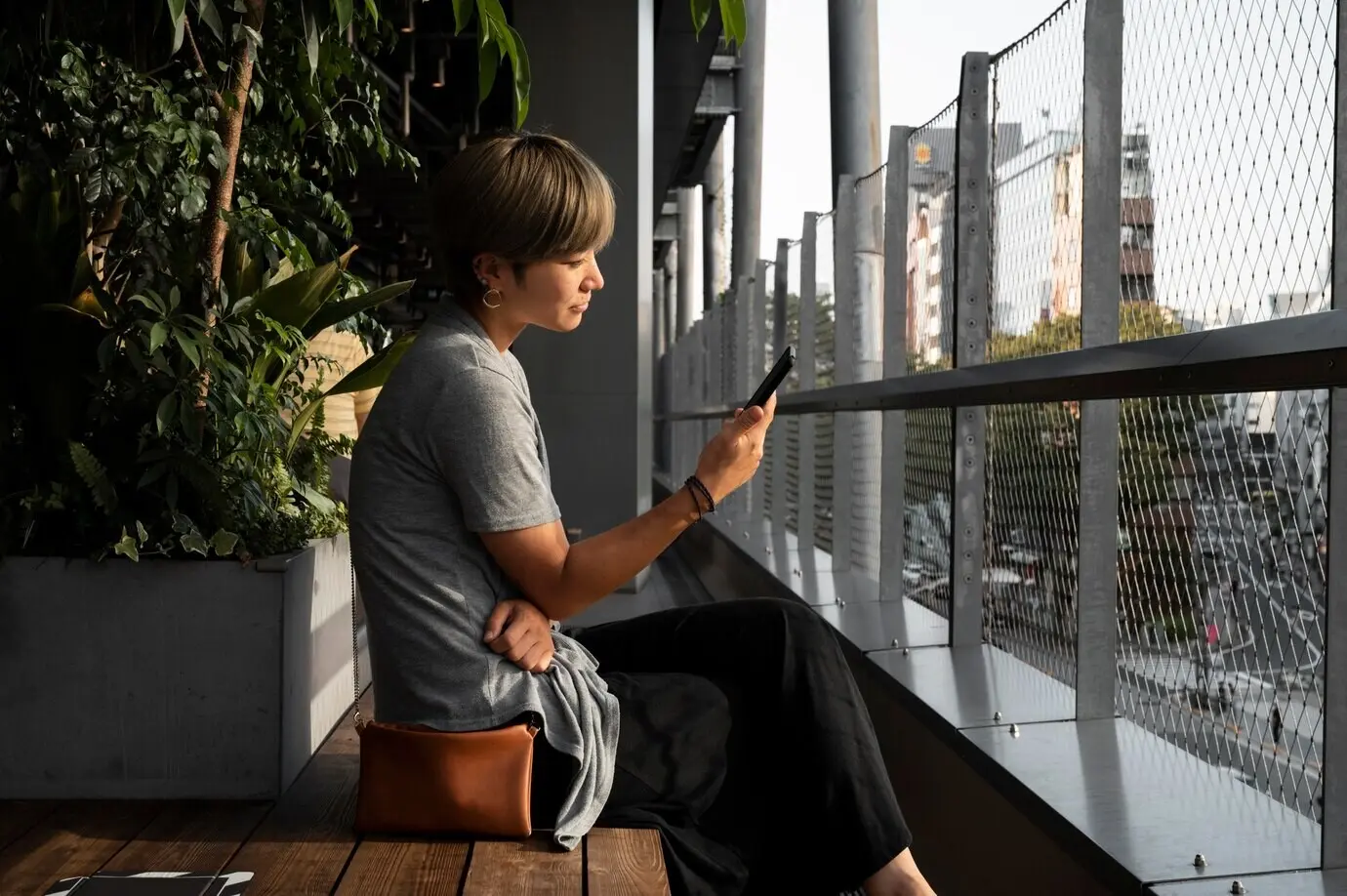 Junge asiatische Frau, die im Freien auf ihr Smartphone schaut